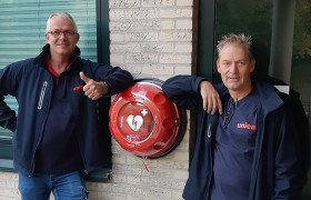 Monteurs van Unica naast een zojuist gemonteerde AED