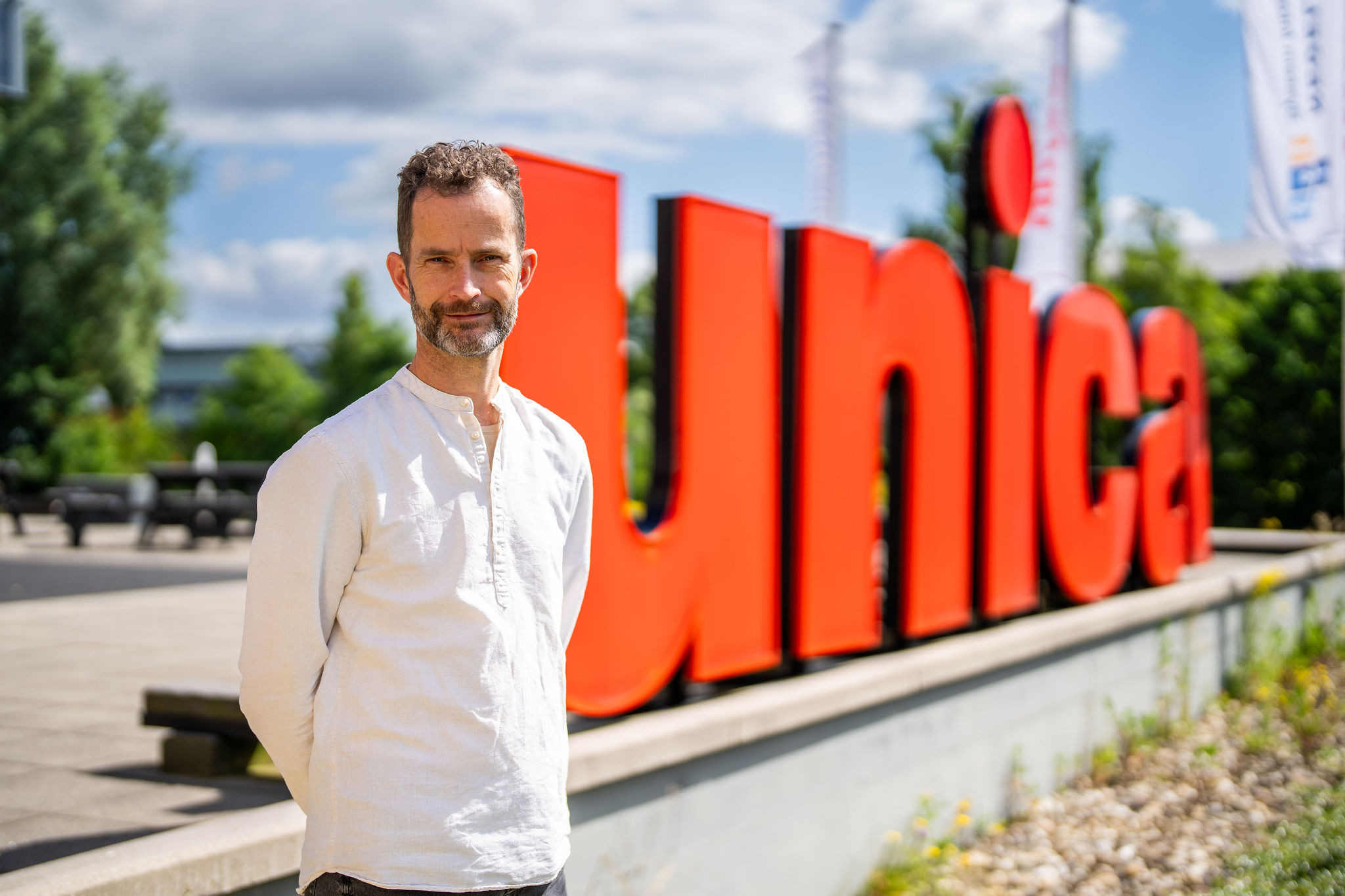 E-mobility specialist Hans den Otter staat voor het Unica logo
